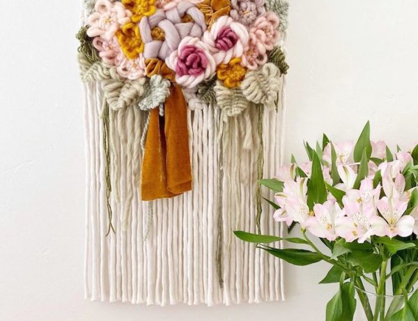 Modern macrame wall hanging with yarn flowers