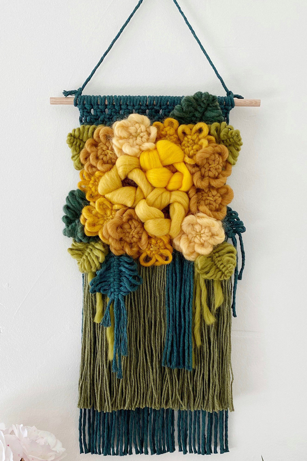 Modern macrame wall hanging with yarn flowers