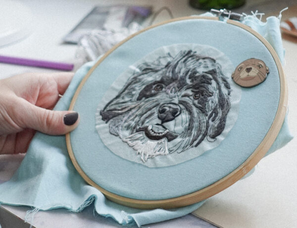 Holding a custom pet portrait in an embroidery hoop