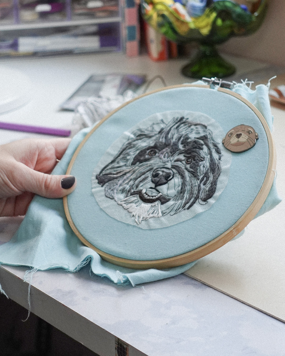 Holding a custom pet portrait in an embroidery hoop