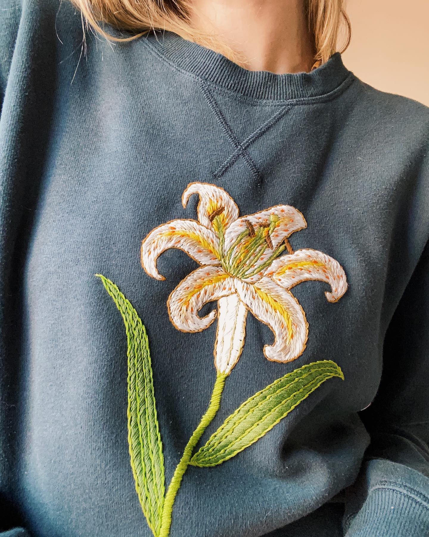 Embroidering on a sweatshirt by Tessa Perlow